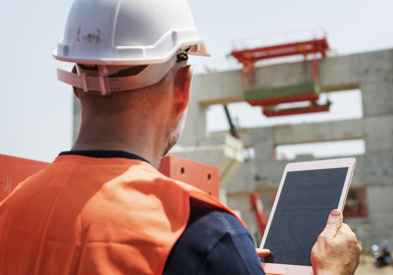 Inspecteur sur chantier avec une tablette pour faire ses notes